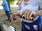 Ingrid schenkt den Likör ein, man sieht ihre linke Hand mit der Flasche, in der rechten hält sie das Glas