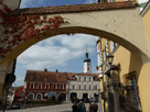Blick durch einen Torbogen, Häuser am Stadtplatz und Kirchturm