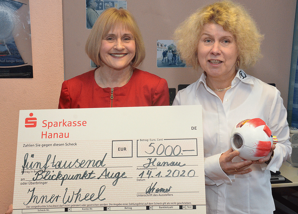 Frau Dr.Carola Kromer hält einen Riesenscheck über 5000 Euro in den Händen, Silvia das Modell eines Auges.