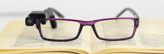 Brille mit Orcam lm rechten Bgel iegt auf einem Buch