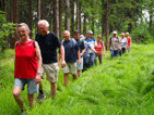 im Gänsemarsch durch hohes Gras am Waldesrand.  von vorne Marlene, Volkhard, Klaus, Heinrich,  Gabi, Ede, Anneliese, Franz, ingrid, Silvia