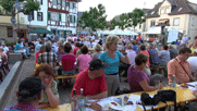 viele Menschen an Biertischen auf dem Platz, unsere Gruppe im Vordergrund