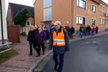 Pitschedabber laufen auf dem Trottoir entlang der Straße, vorne Franz Schilling