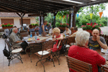 Blick über die Terrasse, die Teilnehzmer sitzen an Tischen