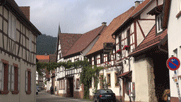 Blick in eine Straße mit Fachwerkhäusern rechts und links.