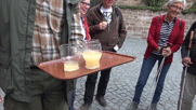 Achim hält ein Tablett, auf dem Gläser mit neuem Wein stehen