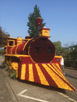 Dampflokomotive mit einer Art "Rammschürze", um Hindernisse aus den Gleisen zu räumen, gestaltet aus gelben, roten und dunkelroten Blumen