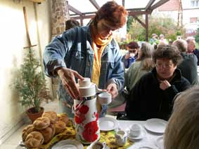 Angela schenkt Kaffee aus der großen Kanne