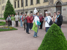 die Gruppe im Park hört Frau Christ zu, im Hintergrund die seitliche Schlossfassade