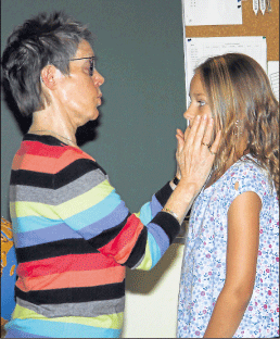 Adele Wolf-Z&ouml;ll betastet dasGesicht eines M&auml;dchens