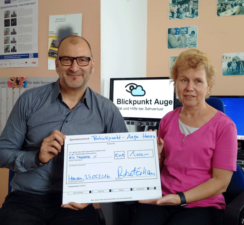 Robert Erkan und Silvia Sch&auml;fer halten einen &uuml;berdimensionalen Scheck &uuml;ber 1000 Euro.