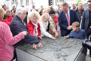 Links stehen Josef, Silvia und Regina am Modell und ertasten es. Dahinter steht Kaminsky