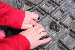 Nahaufnahme von H&auml;nden am Modell an der Franz&ouml;sischen Allee mit intakter Niederl&auml;ndisch-Wallonischer Kirche.