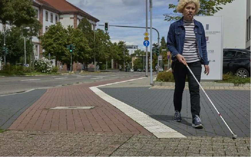 Silvia Sch�fer mit Stock auf einem Gehweg