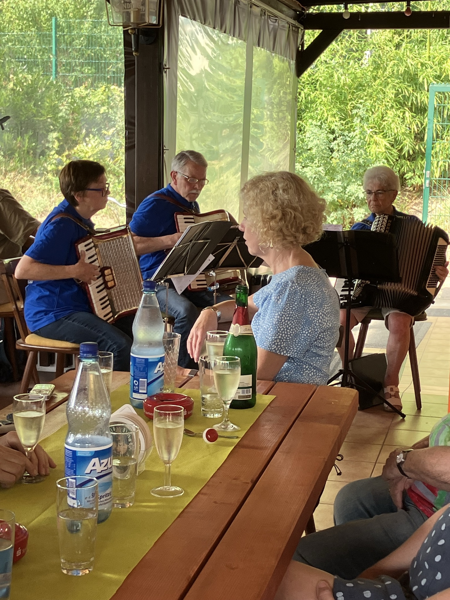 Eine Gruppe von Musikern mit Akkordeons. Auf dem Tisch im Vordergrund stehen Getr�nke.