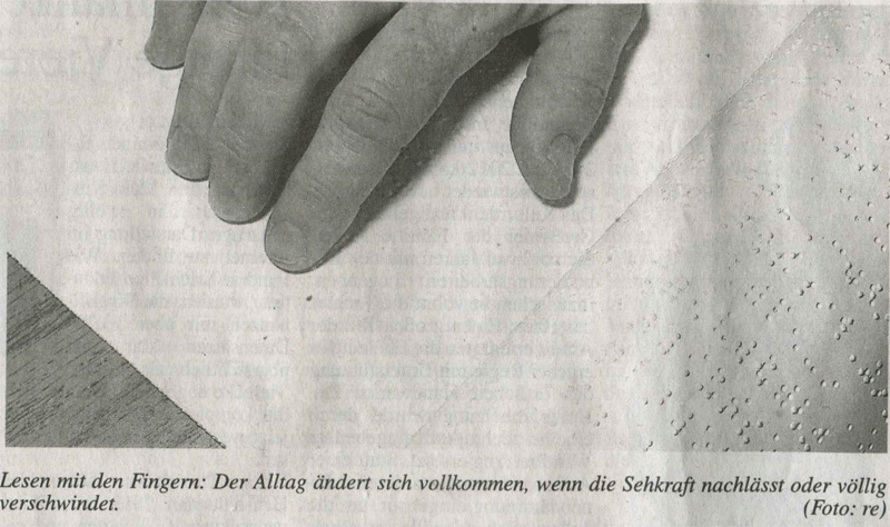 Finger auf einem Text mit Brailleschrift