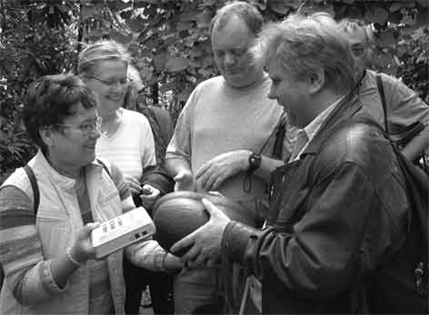 Karin, Regina, Alwin, J&ouml;rg betrachten Samen der Palme